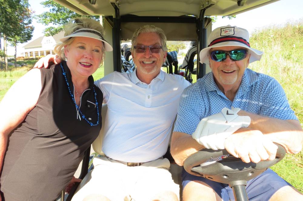 Three people in golf cart